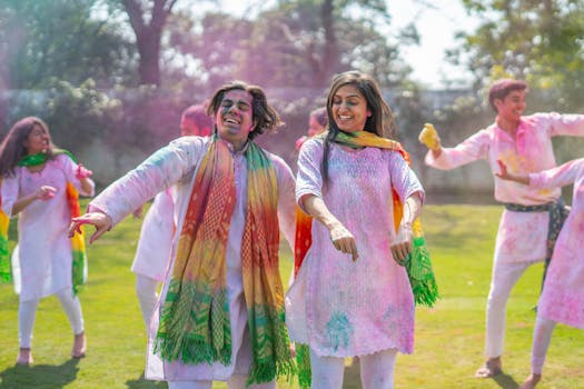 Happy group celebrating Holi festival with colors, enjoying tradition and culture outdoors.