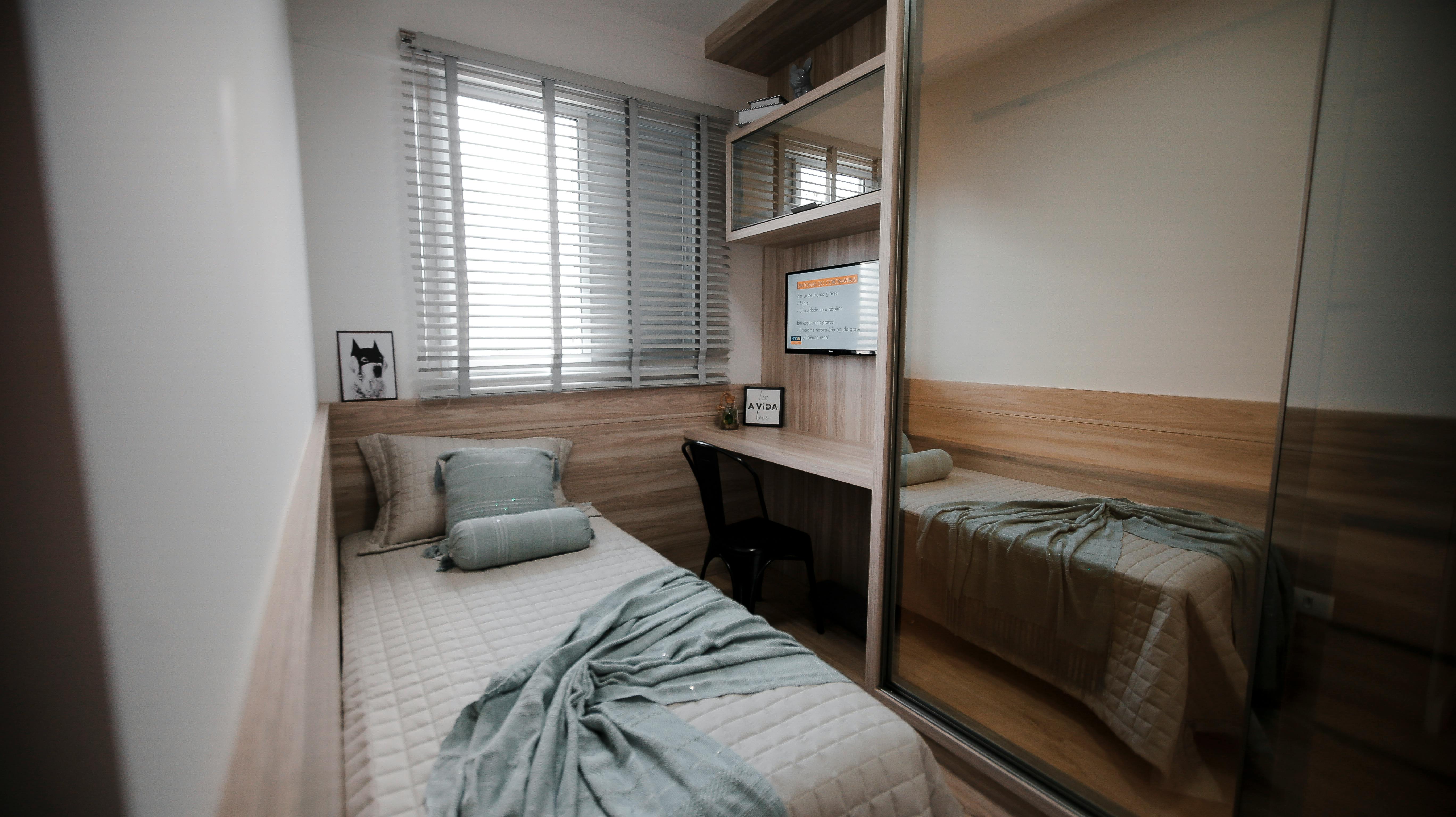 Compact folding desk in cluttered bedroom setup with storage