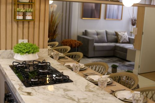 Free Elegant kitchen interior with marble countertops, gas stove, and dining setup. Stock Photo