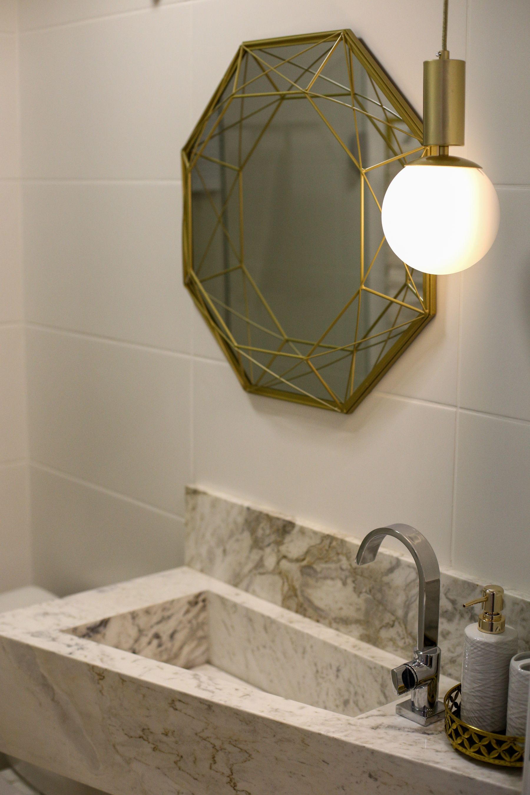 Bathroom vanity with geometric mirror, marble sink and mixed decorative details