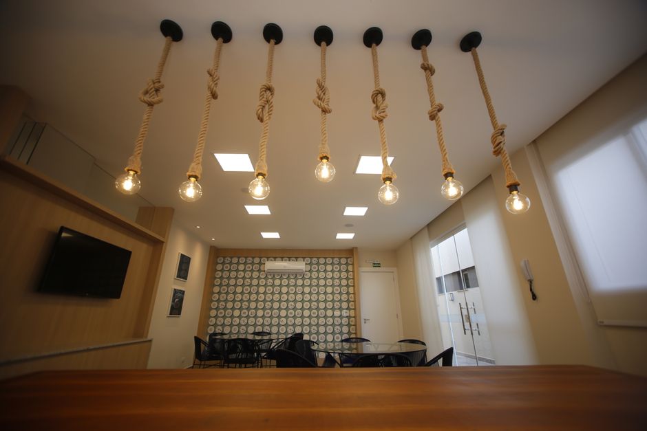 Stylish room interior featuring rope-hung light bulbs and geometric wall design.