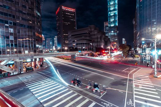Dynamic urban night scene featuring light trails and iconic Taipei 101 skyscraper.
