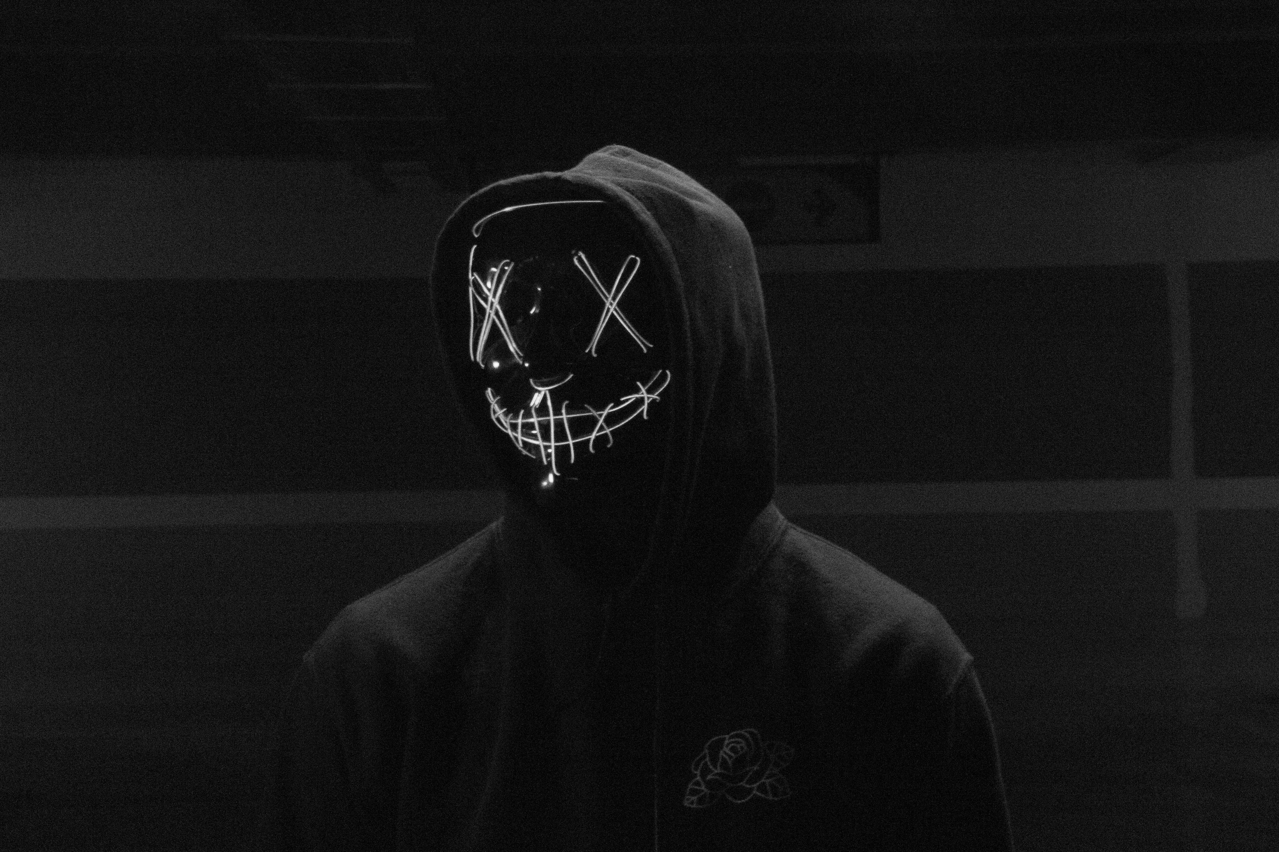 Download A Person Wearing A Neon Mask With A Hoodie Wallpaper