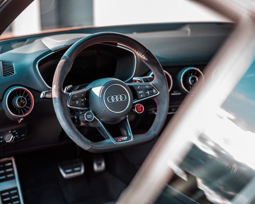 Free Close-up view of a luxury car's interior highlighting a sleek steering wheel and modern dashboard design. Stock Photo