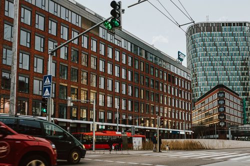 Free Street view of a bustling city intersection with modern commercial buildings. Stock Photo