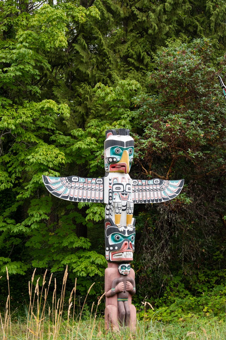 A  Wooden Totem Surrounded By Green Trees