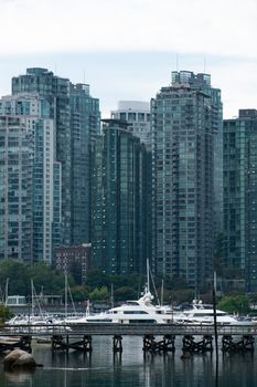 Scenic view of Vancouver's high-rise skyline with yachts at the waterfront.