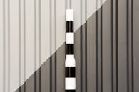 Black and White Pole on the Background of a Wall