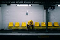 Person in Yellow Jacket on Yellow Chair at Metro Station