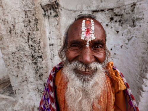 Free Portrait of a joyful elderly man with traditional facial markings, radiating warmth and happiness. Stock Photo