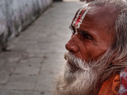 A Bearded Man with Red and White Paint on Forehead