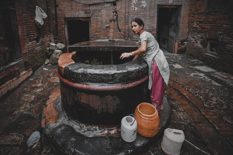 Woman Taking Water From A Well