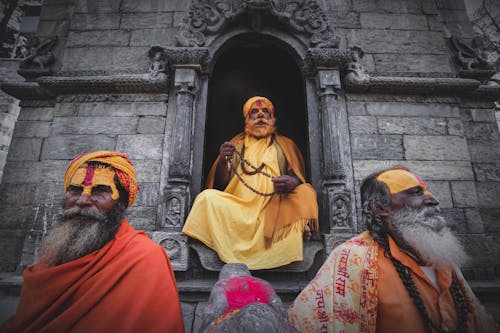 A Group of Elderly Men with yellow and Red Paint on Forehead Praying