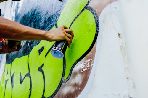 Person Painting on Wall Using Spray Paint
