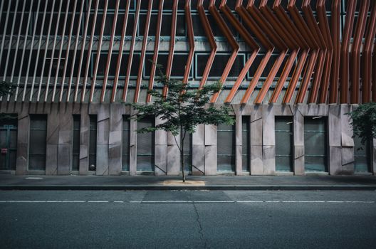 Contemporary building facade with geometric design and an empty urban street.