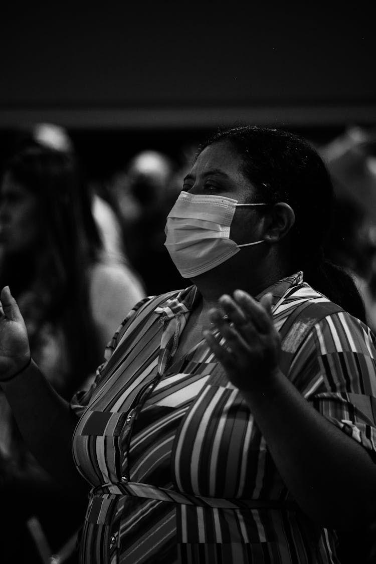 Grayscale Photo Of A Woman In Printed Blouse Praying With Face Mask