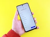 A Person Holding a Smart Phone in Yellow Background