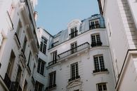 Sunlit view of elegant urban residential buildings in a courtyard with architectural details.