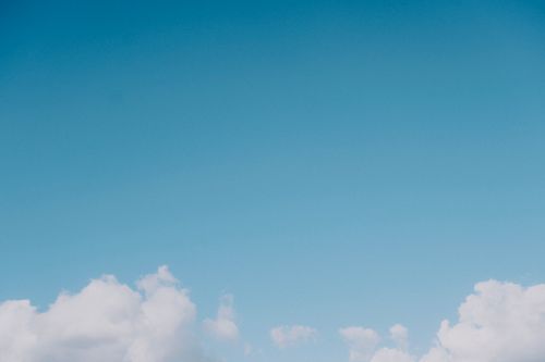 Free A calming blue sky filled with soft, fluffy white clouds, perfect for relaxation and peace. Stock Photo