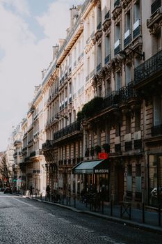 Elegant Paris street scene featuring historic buildings, balconies, and a quaint brasserie.