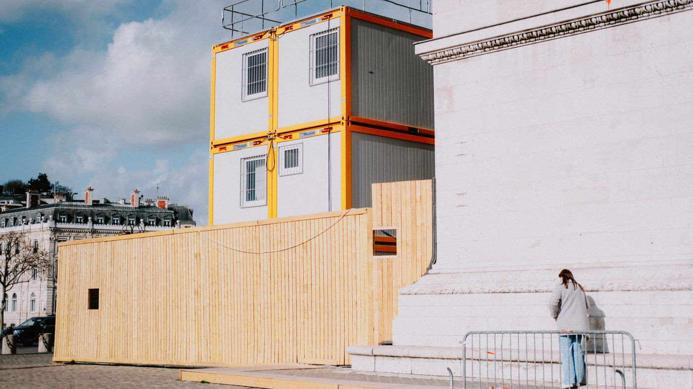 Person walking past stacked modular construction units