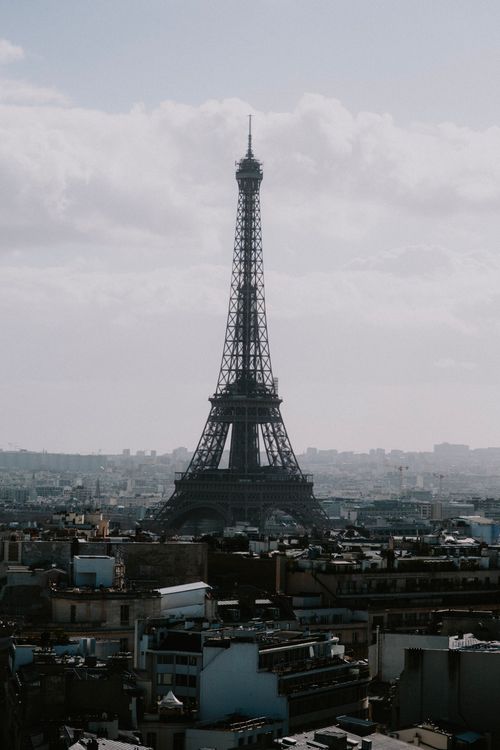 Free Stunning drone shot of the Eiffel Tower against the Parisian skyline on a cloudy day. Stock Photo