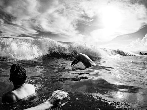 A Person in Water Diving Into Waves