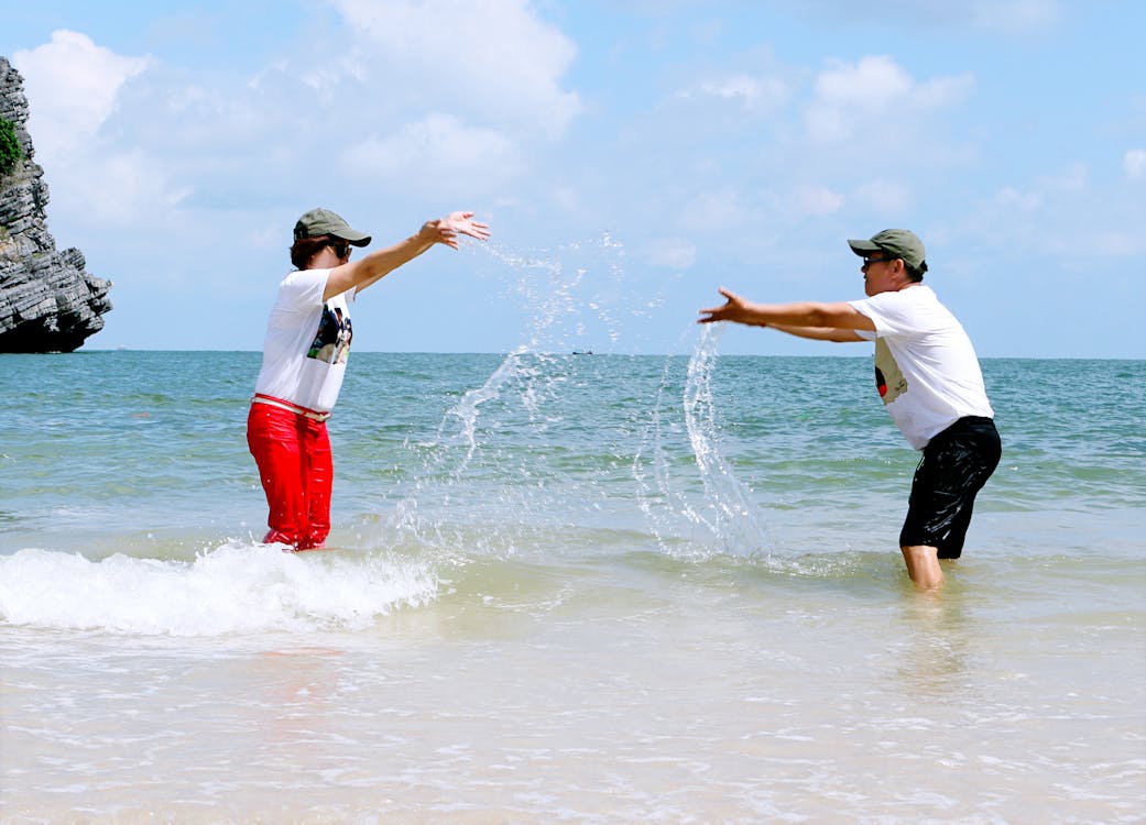 Free Man And Woman Splashing Water To Each Other  Stock Photo