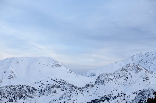 Snow Covered Mountains Under White Sky