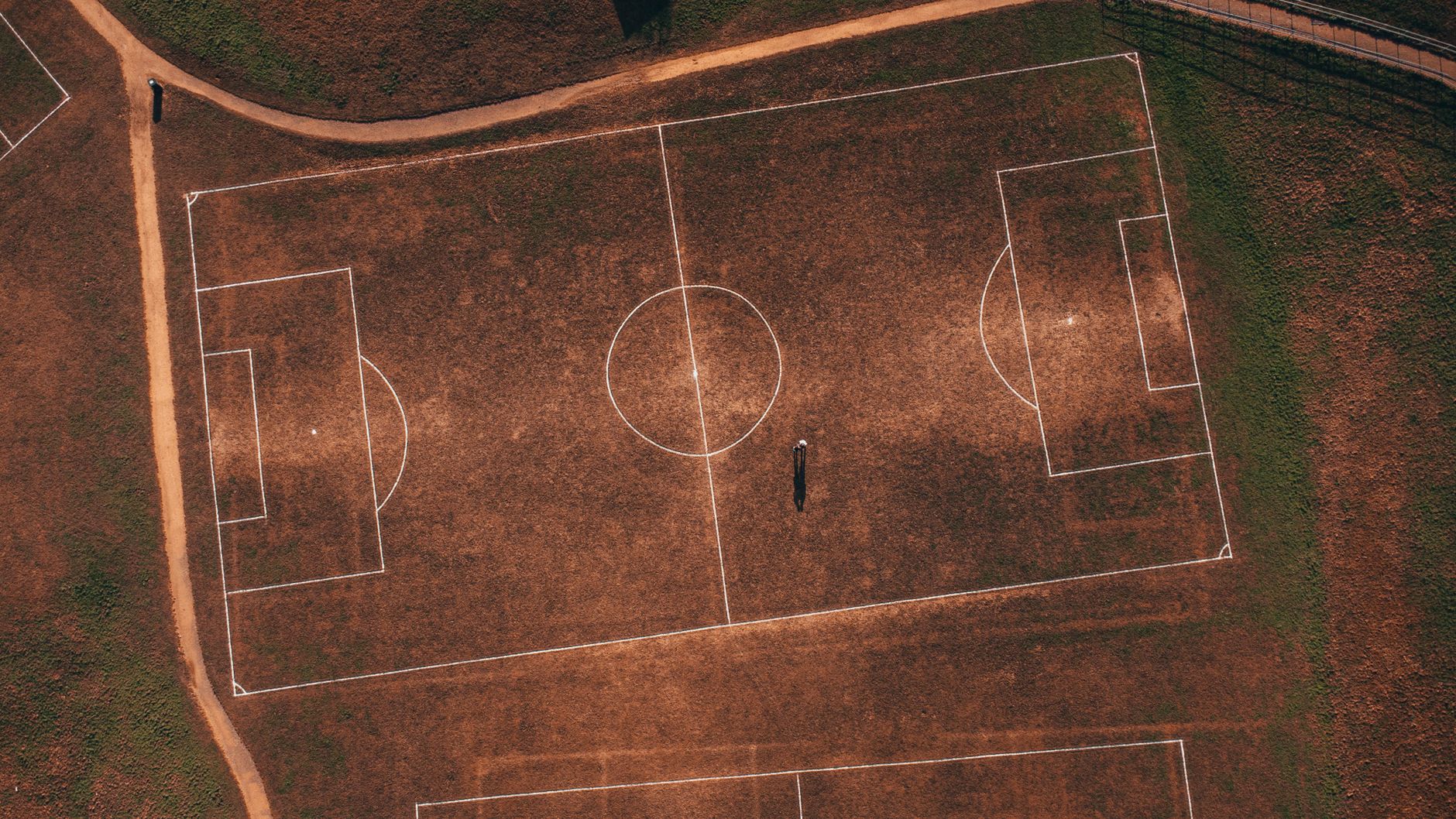 aerial football pitch diagram comparing a compact 4-4-2 block with an expansive 4-3-3 attack