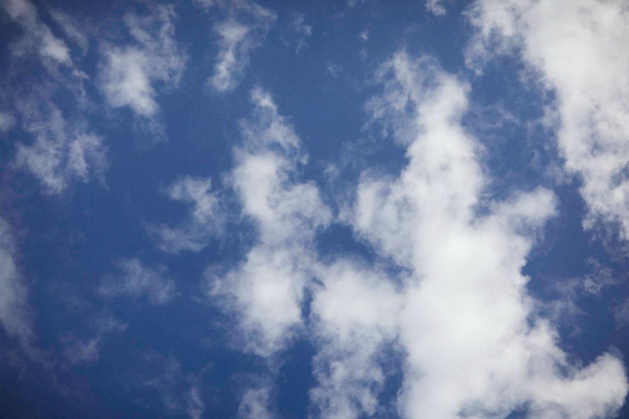 a tranquil view of a clear blue sky dotted with soft fluffy white clou