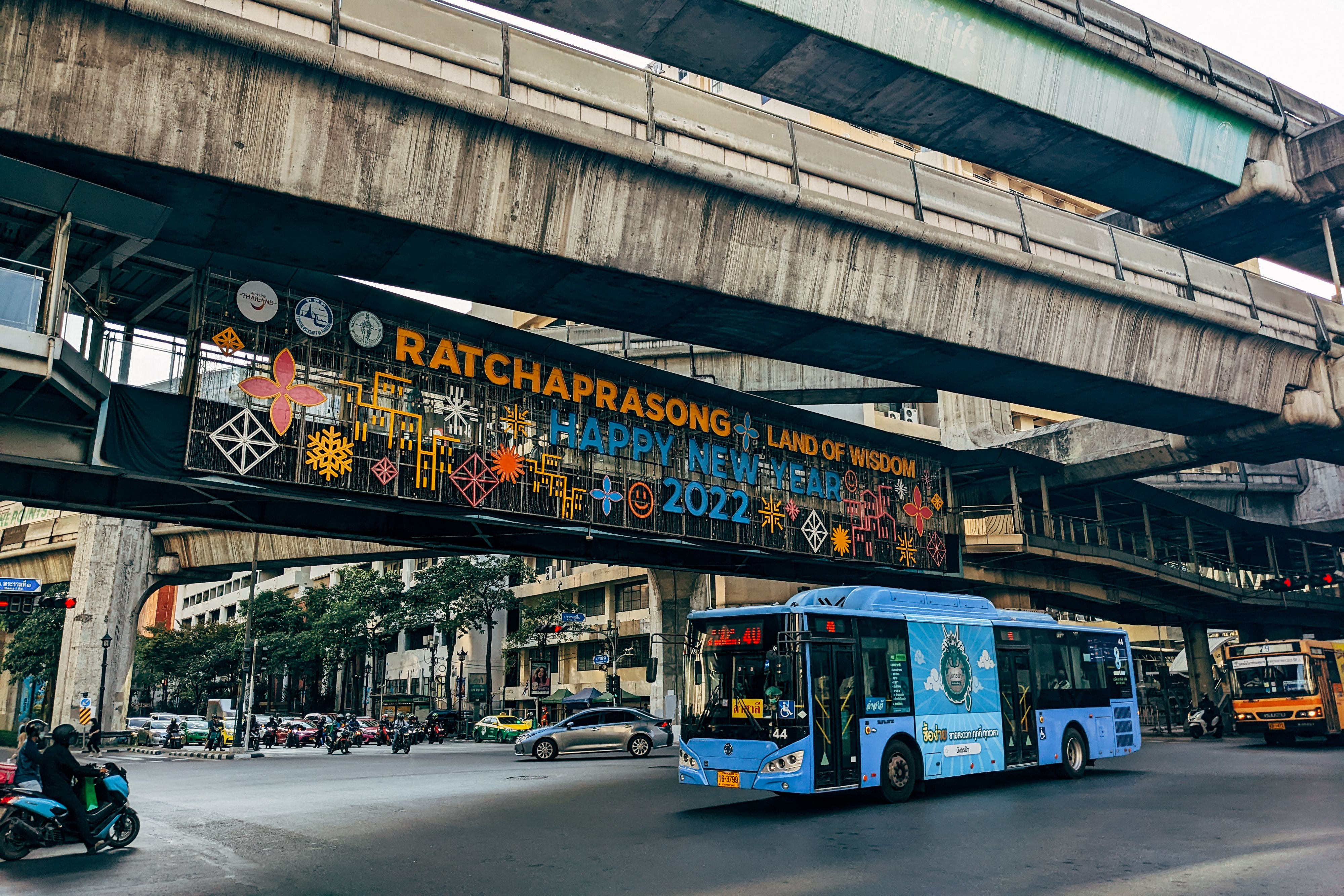 BTS Skytrain platform above a busy Bangkok intersection at rush hour