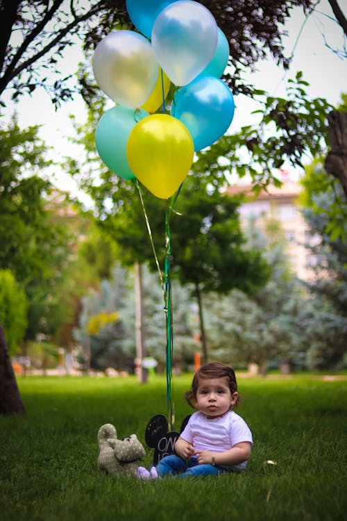 Free Baby' With Blue and Yellow Balloons Stock Photo