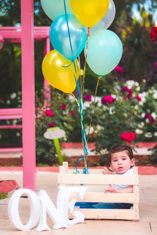 Free Adorable child with colorful balloons in a garden, celebrating first birthday. Stock Photo