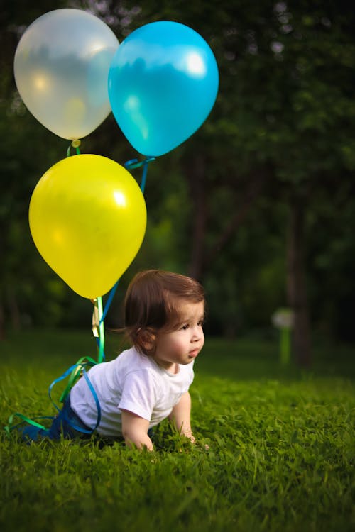 Baby crawling Baby Wearing White Shirt Tied With Three Balloons