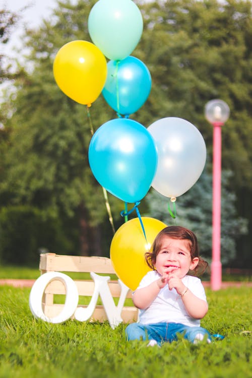 Fille Portant Une Chemise Blanche Près De Ballons Sarcelle, Blanc Et Jaune