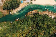 俯瞰热带海滩、绿色森林和翡翠水域中船只的风景