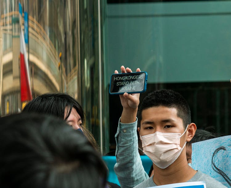 A Person Holding A Smartphone With A Support Message For Ukraine