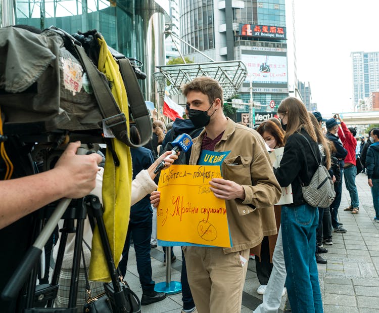 A Young Man Talking To The Press During A Peaceful Protest Against War