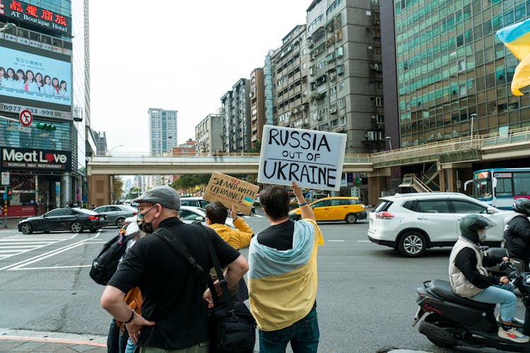 Back View Of People In Street Holding Signs Against The War In Ukraine