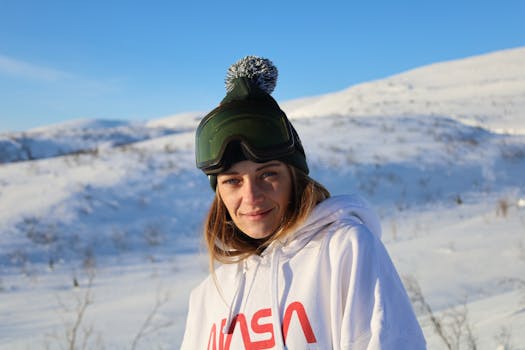 Smiling woman in winter gear enjoys the snowy landscape of Kirovsk, Russia.