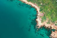 岩石海岸线、清澈的绿松石水域和充满活力的绿色植物构成了一幅令人惊叹的鸟瞰图，不见人类踪迹