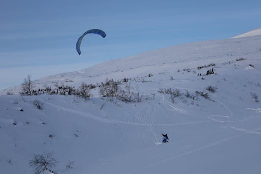 A thrilling sight of kitesurfing on a snowy mountain in Kirovsk, Russia.