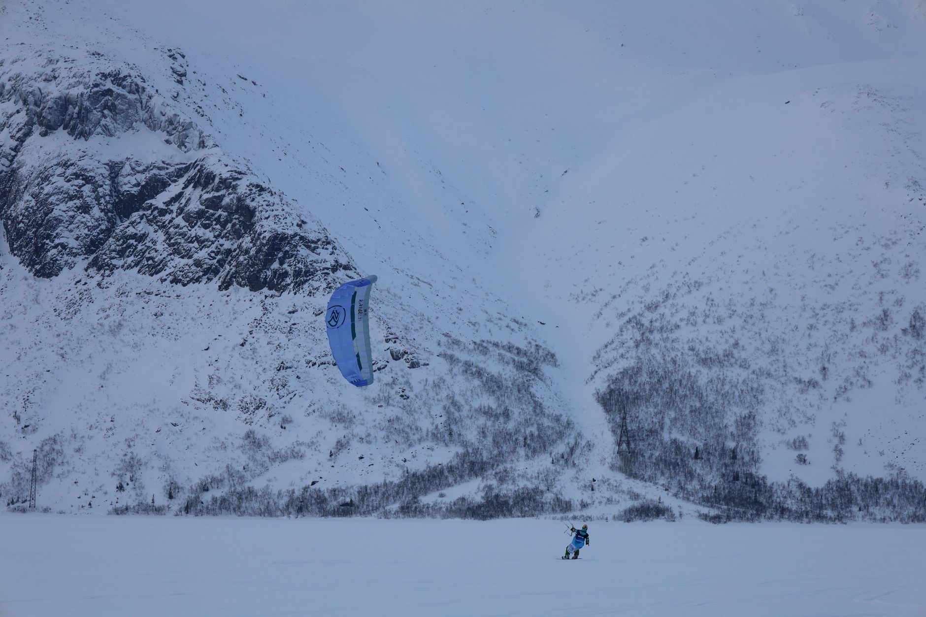 A thrilling snowkiting experience against the snowy mountains of Kirovsk, Russia.