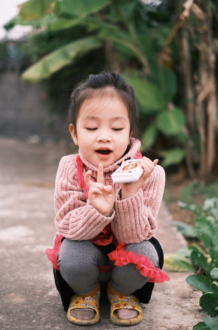 A Girl Holding A Deck Of Cards