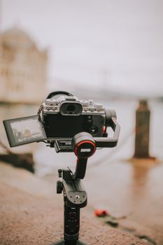 A professional camera mounted on a gimbal by a waterfront setting, ready for outdoor photography.