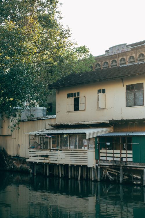 Free An old house on stilts by a calm waterfront, reflecting a rustic vibe amidst nature. Stock Photo
