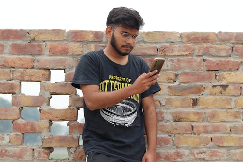 Man in Black Crew Neck T-shirt Holding a Phone