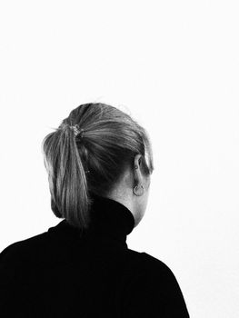 Elegant black and white portrait featuring a woman with a ponytail, captured from behind.