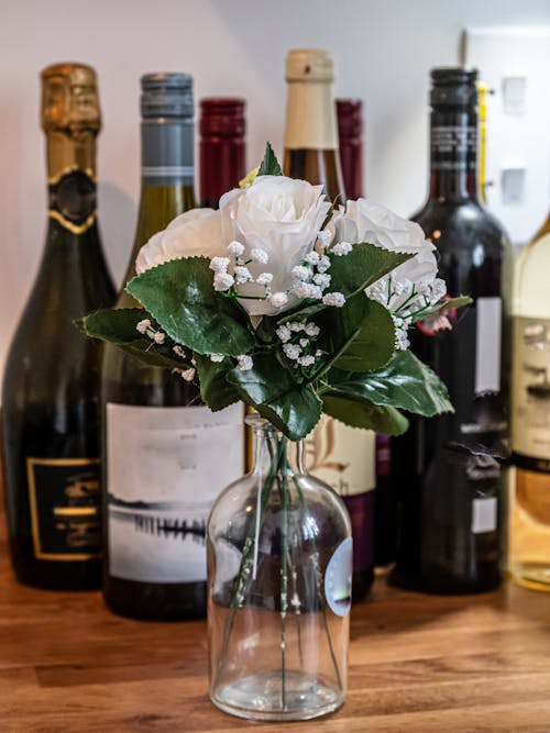 Fake Roses in a Vase and Alcohol Bottles 